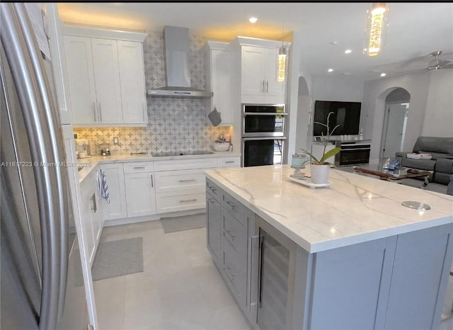 14121 SW 152nd Ter, Miami, FL 33177 - kitchen featuring wall chimney exhaust hood, appliances with stainless steel finishes, beverage cooler, arched walkways, and a kitchen island