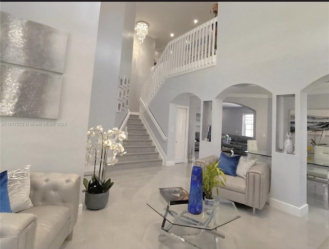 14121 SW 152nd Ter, Miami, FL 33177 - living room featuring stairway, arched walkways, a towering ceiling, and concrete floors