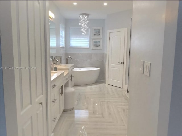 14121 SW 152nd Ter, Miami, FL 33177 - bathroom with vanity, a soaking tub, a chandelier, and tile walls