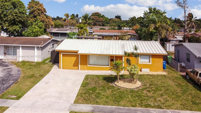 6541 NW 24th St, Sunrise, FL 33313 - view of front facade with driveway, stucco siding, metal roof, cooling unit, and an attached garage