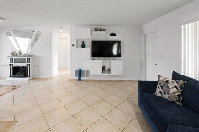6541 NW 24th St, Sunrise, FL 33313 - living area featuring light tile patterned flooring, baseboards, and a fireplace with raised hearth
