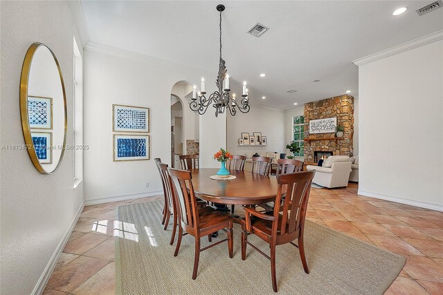 112 Segovia Way, Jupiter, FL 33458 - dining space featuring crown molding, arched walkways, baseboards, a chandelier, and a fireplace