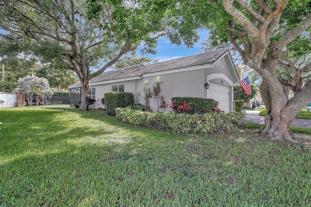 9012 Lake Park Cir S, Davie, FL 33328 - view of home's exterior featuring a garage, stucco siding, a lawn, and a tile roof