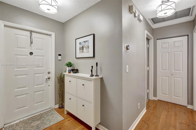 9012 Lake Park Cir S, Davie, FL 33328 - foyer entrance with a textured ceiling, light wood finished floors, and baseboards