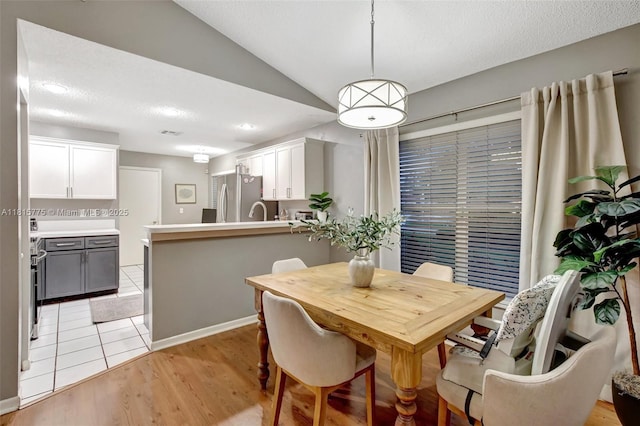 9012 Lake Park Cir S, Davie, FL 33328 - dining space with vaulted ceiling, light wood-style floors, and a textured ceiling