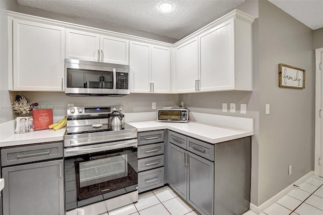 9012 Lake Park Cir S, Davie, FL 33328 - kitchen featuring stainless steel appliances, gray cabinets, light tile patterned floors, a textured ceiling, and light countertops