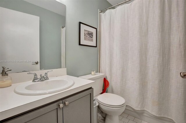 9012 Lake Park Cir S, Davie, FL 33328 - bathroom with toilet, vanity, tile patterned floors, and shower / bathtub combination with curtain