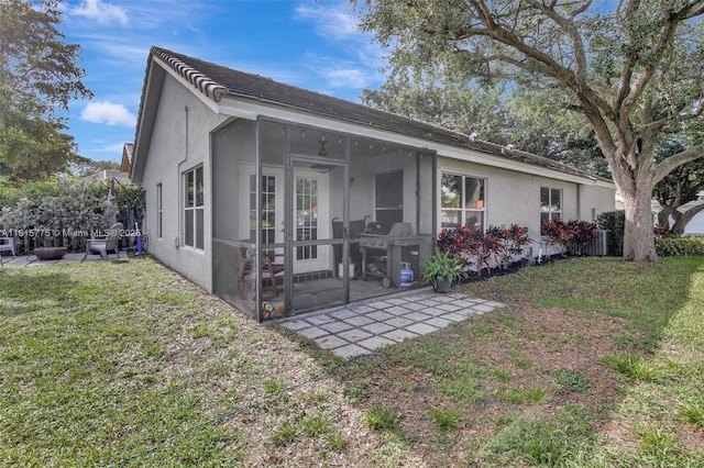 9012 Lake Park Cir S, Davie, FL 33328 - rear view of property with a sunroom, stucco siding, a patio area, and a lawn