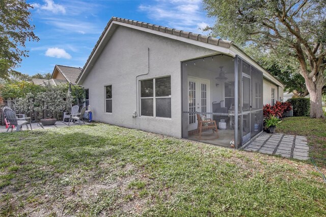 9012 Lake Park Cir S, Davie, FL 33328 - rear view of house with a fire pit, a patio area, stucco siding, and a lawn