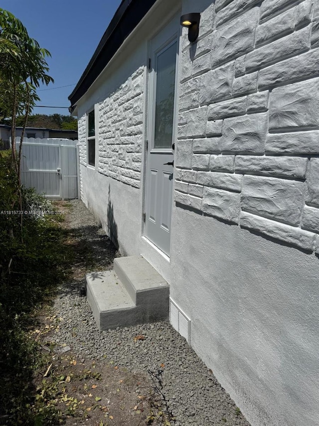 1794 NW 74th Ter, Miami, FL 33147 - view of side of home featuring stone siding and stucco siding