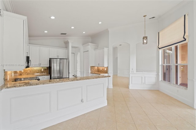 7215 Great Falls Cir, Boynton Beach, FL 33437 - kitchen with freestanding refrigerator, ornamental molding, light stone countertops, arched walkways, and backsplash