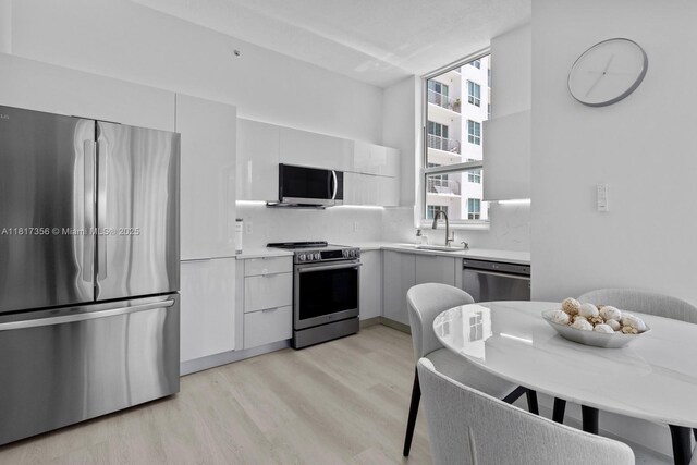 133 NE 2nd Ave Unit 2712, Miami, FL 33132 - kitchen featuring appliances with stainless steel finishes, light wood-style flooring, modern cabinets, and light countertops