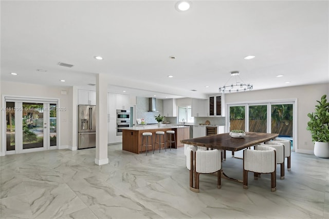12985 Ortega Ln, North Miami, FL 33181 - dining room with recessed lighting, baseboards, light marble finish flooring, and a chandelier