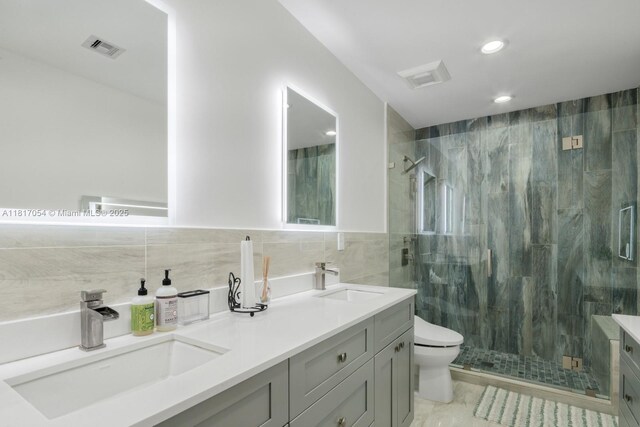 12985 Ortega Ln, North Miami, FL 33181 - bathroom featuring tile walls, double vanity, toilet, a marble finish shower, and recessed lighting