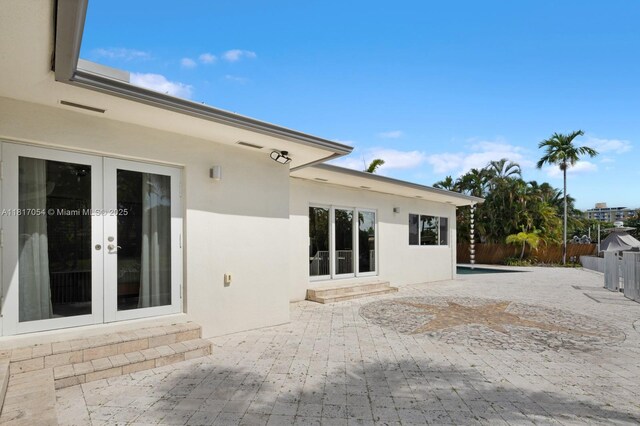 12985 Ortega Ln, North Miami, FL 33181 - rear view of house featuring french doors, a patio, and stucco siding