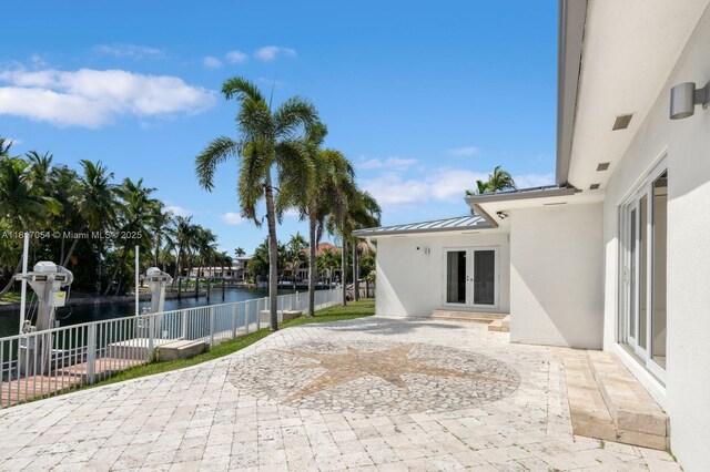 12985 Ortega Ln, North Miami, FL 33181 - view of patio / terrace featuring french doors and a water view