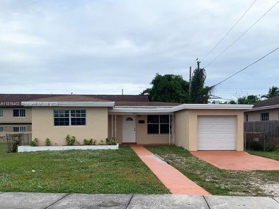 2401 NW 7th St, Fort Lauderdale, FL 33311 - single story home featuring stucco siding, an attached garage, and driveway
