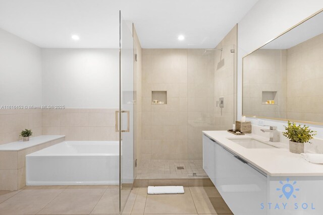 777 N Ocean Dr Unit N219, Hollywood, FL 33019 - bathroom featuring vanity, a bath, a shower stall, tile patterned floors, and recessed lighting