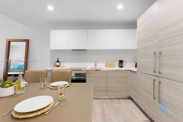 777 N Ocean Dr Unit N219, Hollywood, FL 33019 - kitchen with oven, modern cabinets, a sink, light countertops, and white cabinets