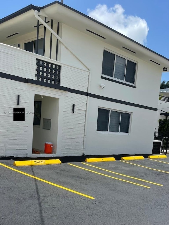 251 NW 57th Ave, Miami, FL 33126 - view of side of home with uncovered parking, a balcony, and stucco siding