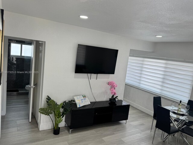 251 NW 57th Ave, Miami, FL 33126 - living room featuring a desk, a textured ceiling, baseboards, light wood-style floors, and recessed lighting
