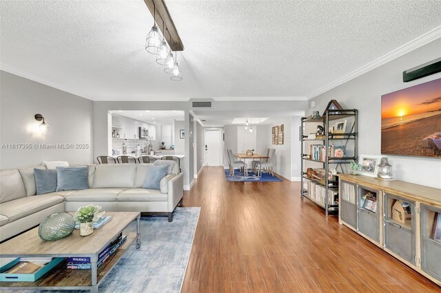 1100 SE 5th Ct Unit 87, Pompano Beach, FL 33060 - living area featuring a textured ceiling, wood finished floors, ornamental molding, and track lighting