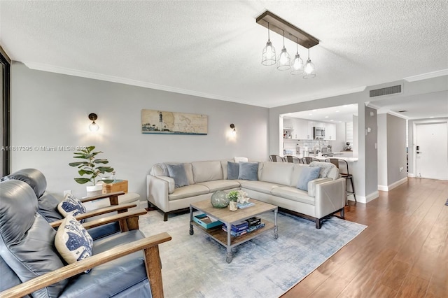 1100 SE 5th Ct Unit 87, Pompano Beach, FL 33060 - living area featuring a textured ceiling, crown molding, wood finished floors, and baseboards