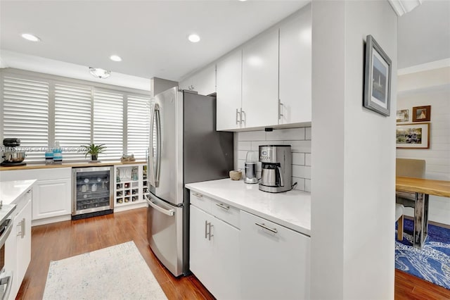 1100 SE 5th Ct Unit 87, Pompano Beach, FL 33060 - kitchen with wine cooler, freestanding refrigerator, dark wood-type flooring, white cabinetry, and decorative backsplash