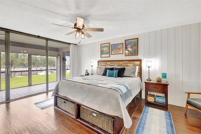 1100 SE 5th Ct Unit 87, Pompano Beach, FL 33060 - bedroom with access to exterior, wood finished floors, a textured ceiling, and a ceiling fan