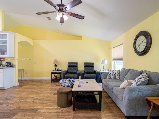 508 Arcadia Ave NE, Palm Bay, FL 32907 - living room featuring lofted ceiling, ceiling fan, wood finished floors, arched walkways, and baseboards