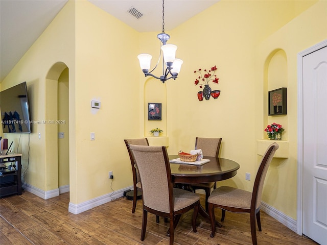 508 Arcadia Ave NE, Palm Bay, FL 32907 - dining space featuring wood finished floors, a chandelier, baseboards, and arched walkways