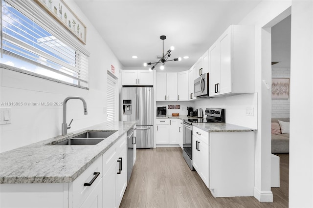 1013 S 24th Ave, Hollywood, FL 33020 - kitchen featuring stainless steel appliances, a sink, light wood-style floors, a chandelier, and recessed lighting