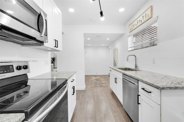 1013 S 24th Ave, Hollywood, FL 33020 - kitchen with stainless steel appliances, a sink, light wood-style flooring, light stone countertops, and white cabinetry