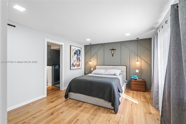 9310 Sunrise Lakes Blvd Unit 206, Sunrise, FL 33322 - bedroom featuring baseboards, light wood finished floors, and a decorative wall