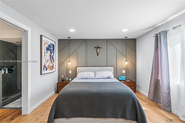 9310 Sunrise Lakes Blvd Unit 206, Sunrise, FL 33322 - bedroom with a decorative wall, light wood-style flooring, and baseboards