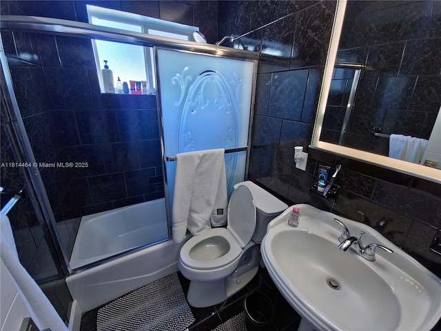 1720 SW 64th Ave, North Lauderdale, FL 33068 - bathroom with a sink, shower / bath combination with glass door, toilet, tile patterned flooring, and tile walls