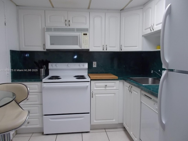 800 W Ave Unit 422, Miami Beach, FL 33139 - kitchen featuring white appliances, a sink, light tile patterned floors, and white cabinets