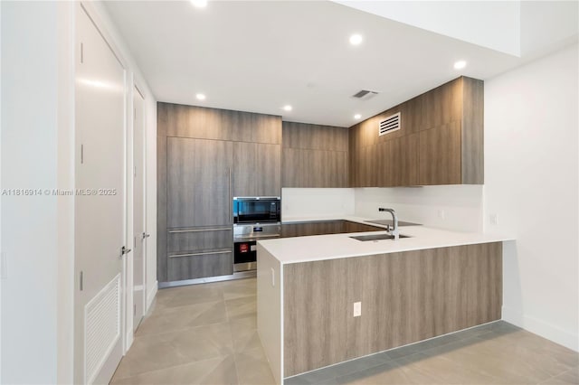 17550 Collins Unit 1604, Sunny Isles Beach, FL 33160 - kitchen featuring a sink, modern cabinets, a peninsula, light countertops, and recessed lighting