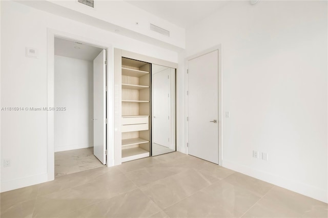 17550 Collins Unit 1604, Sunny Isles Beach, FL 33160 - unfurnished bedroom featuring a closet, baseboards, and marble look tiles