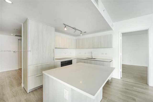3131 NE 7th Ave Unit 3101, Miami, FL 33137 - kitchen with a sink, oven, modern cabinets, black electric cooktop, and light countertops