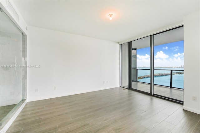 3131 NE 7th Ave Unit 3101, Miami, FL 33137 - unfurnished room with floor to ceiling windows, wood finished floors, and a water view