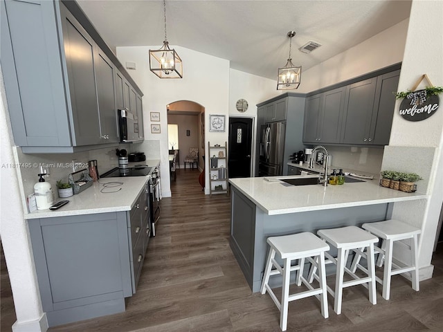 6871 SW 159th Pl, Miami, FL 33193 - kitchen featuring appliances with stainless steel finishes, arched walkways, a chandelier, and a peninsula