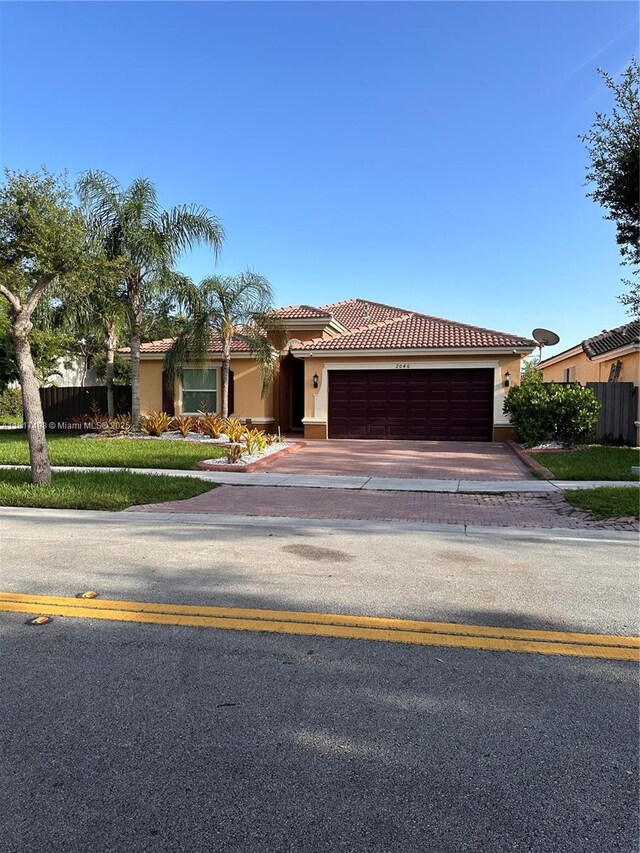 2046 NE 4th Ct, Homestead, FL 33033 - mediterranean / spanish-style home with stucco siding, a garage, a tile roof, and driveway