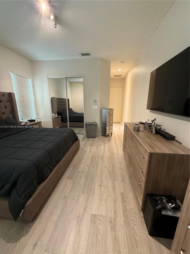 2046 NE 4th Ct, Homestead, FL 33033 - bedroom with light wood-style flooring, a textured ceiling, and a closet