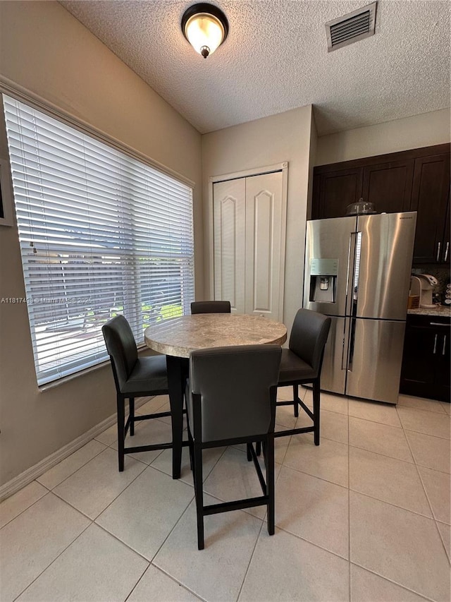 2046 NE 4th Ct, Homestead, FL 33033 - dining area featuring a textured ceiling, light tile patterned floors, and baseboards