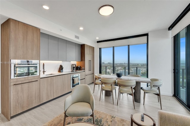 580 72nd St Unit 1712, Miami, FL 33141 - kitchen with modern cabinets, stainless steel oven, light wood finished floors, light countertops, and recessed lighting
