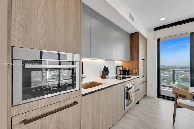 580 72nd St Unit 1712, Miami, FL 33141 - kitchen featuring oven, modern cabinets, black electric stovetop, and light countertops