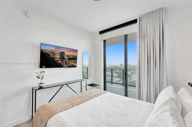 580 72nd St Unit 1712, Miami, FL 33141 - bedroom featuring access to outside, wood finished floors, and expansive windows