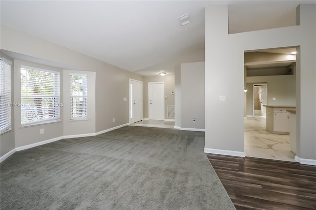138 SW Bedford Rd, Port St Lucie, FL 34953 - unfurnished living room with baseboards, lofted ceiling, and wood finished floors