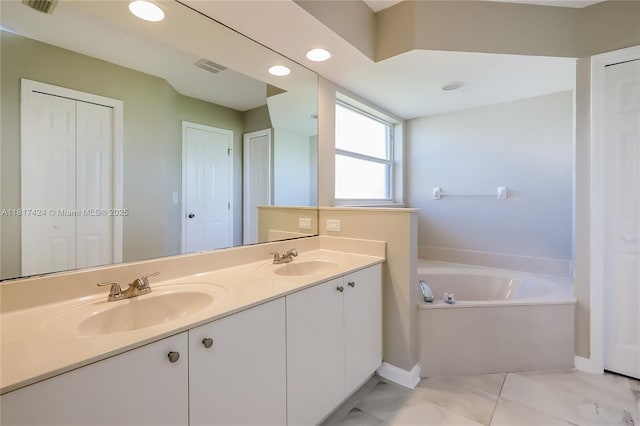 138 SW Bedford Rd, Port St Lucie, FL 34953 - bathroom featuring double vanity, a garden tub, a closet, baseboards, and recessed lighting